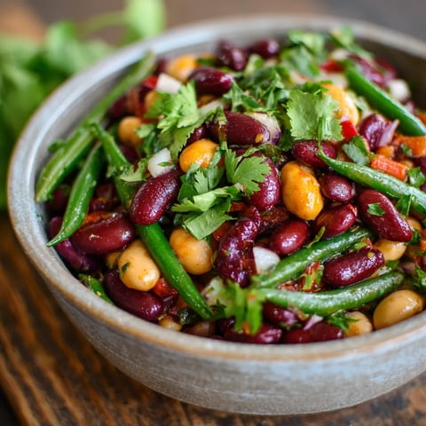 A bowl of three bean salad with green beans, red beans, and chickpeas.